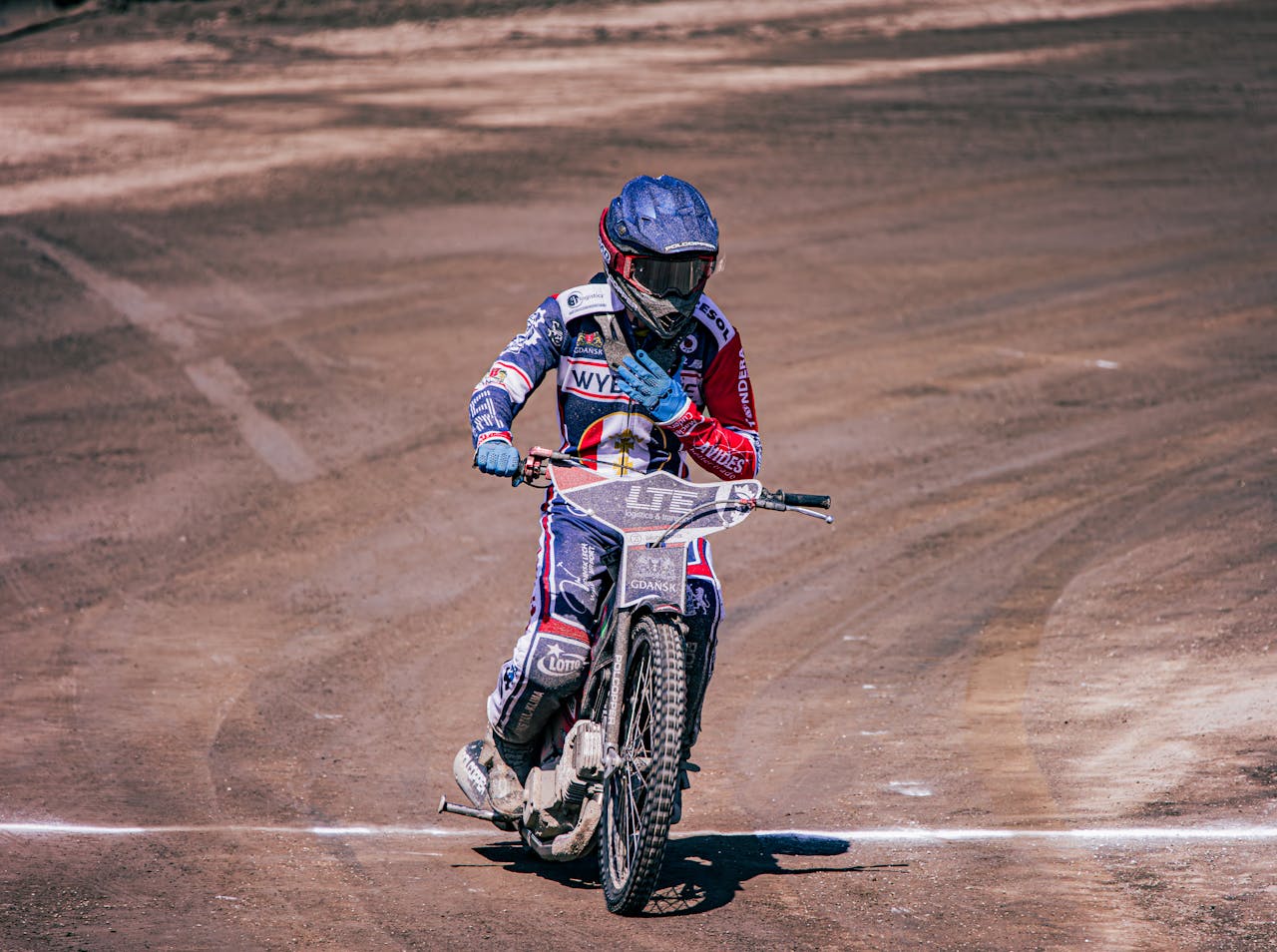 A person riding a motorcycle on a dirt track