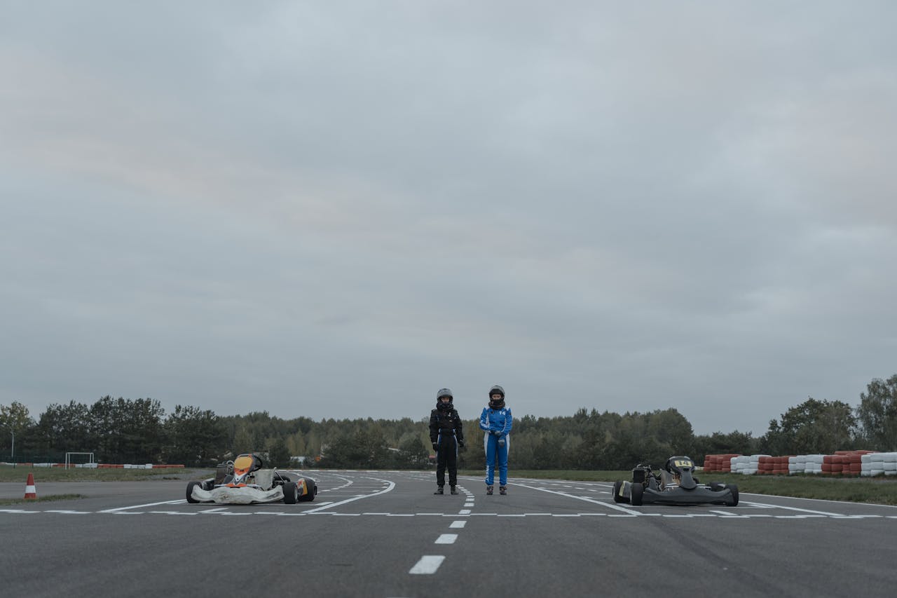 Two Go-Kart Drivers Standing in Racetrack