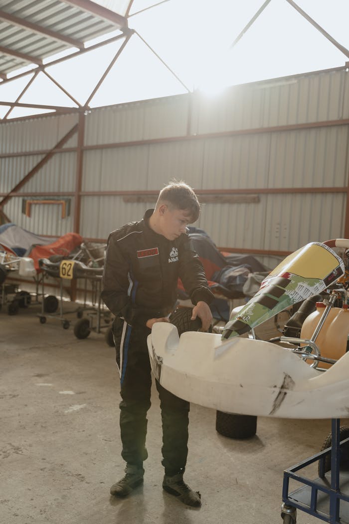 Man in Racing Suit Checking His Go-Kart in the Garage